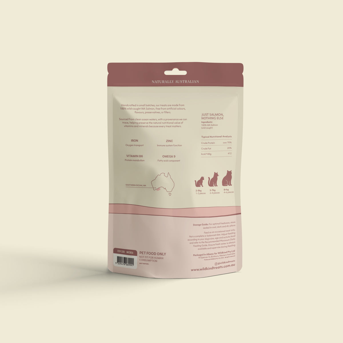 A stand-up pouch of pet food supplement shown from the back on a warm off-white background. The packaging is cream with dusty rose and pink bands, featuring text, icons of cats, and a small map illustration.